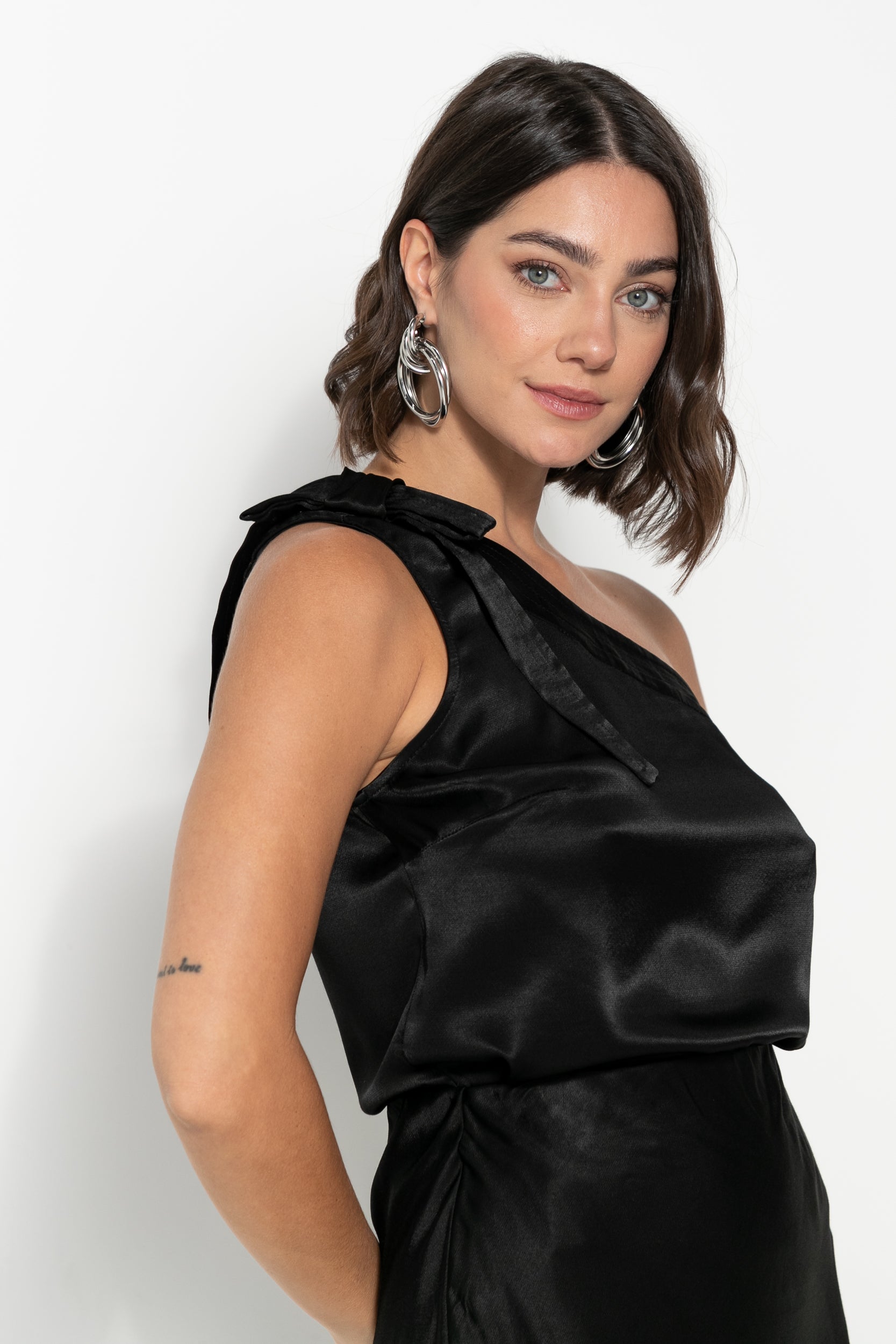 Conjunto acetinado de saia midi e blusa one shoulder, cor preto e vermelho escuro